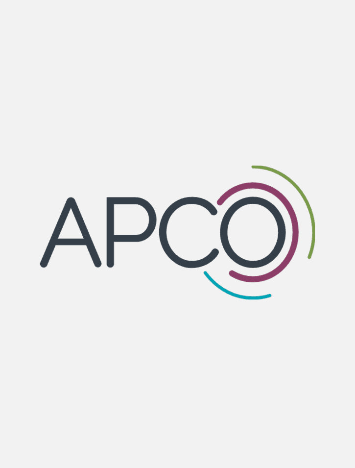 The image shows the word APCO in dark gray letters. The letter O is surrounded by three curved lines in green, purple, and blue, forming a partial circular design. The background is light gray.