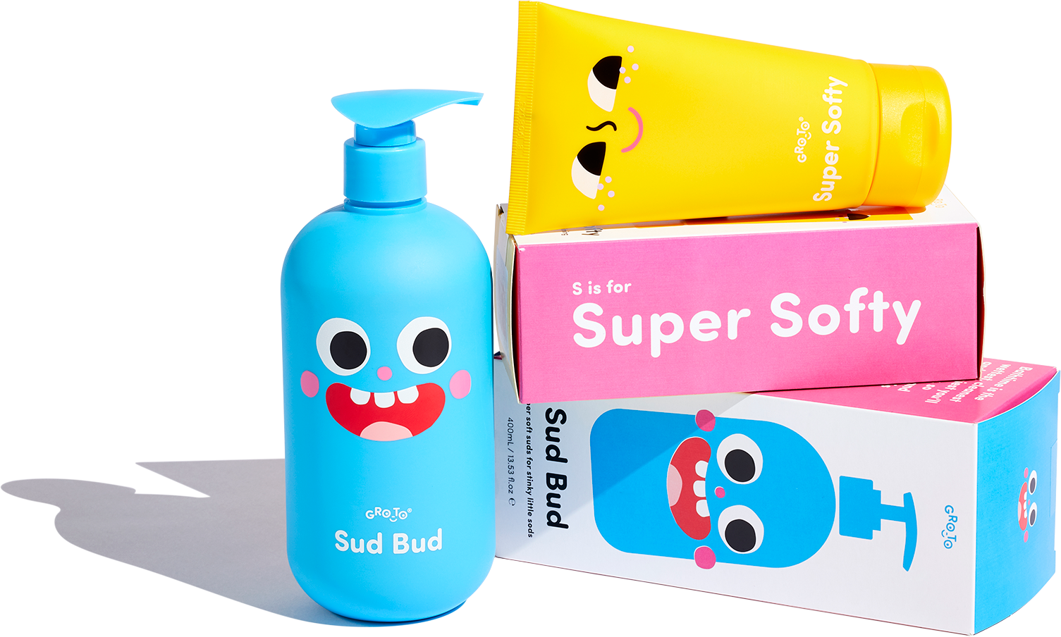 A blue pump bottle labeled Sud Bud and a yellow tube labeled Super Softy, both with playful cartoon faces, are displayed with their colorful packaging in pink, blue, and white.
